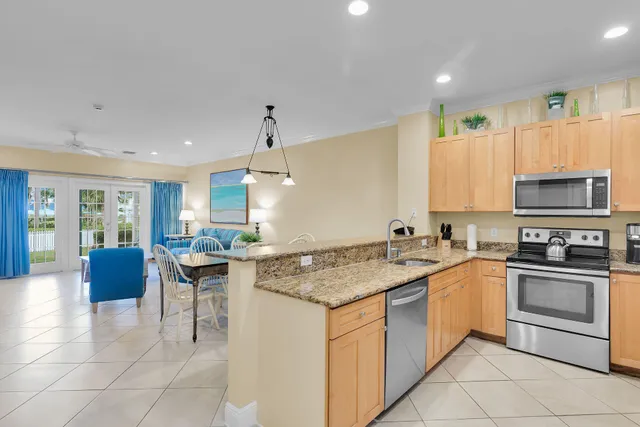 a kitchen with stainless steel appliances granite countertop a refrigerator a stove and a sink