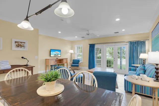 a kitchen with stainless steel appliances granite countertop a dining table chairs and a refrigerator