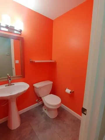 a bathroom with a toilet a sink and mirror