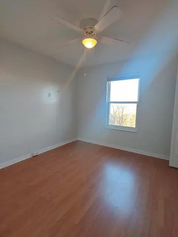 an empty room with a window and a fan