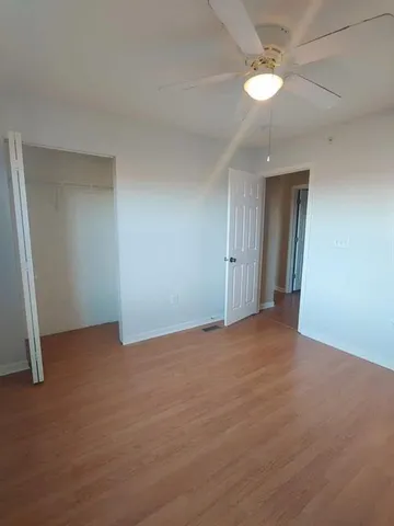 a view of an empty room with a chandelier fan