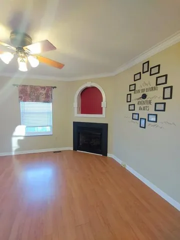 a view of empty room with fireplace and window