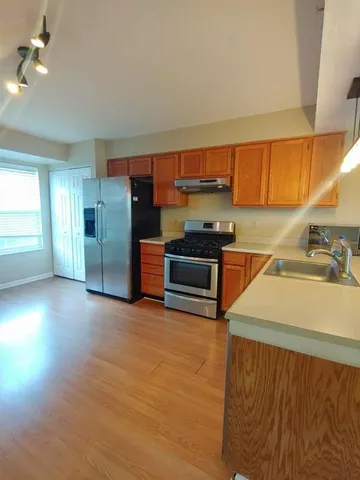a kitchen with stainless steel appliances a sink dishwasher stove and refrigerator