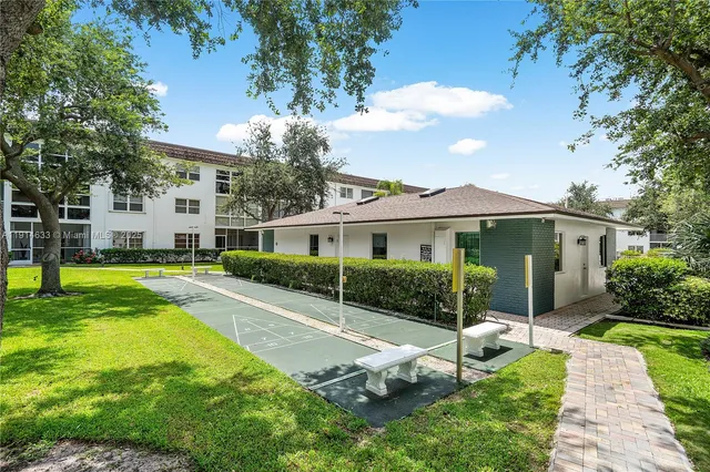 a view of house with garden and tall tress