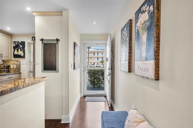 a view of a hallway with wooden floor and living room