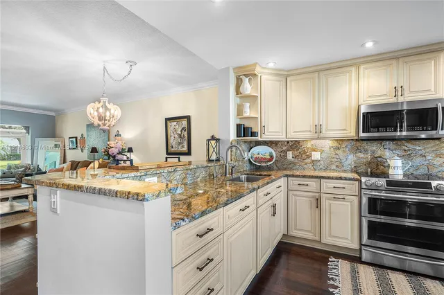 a kitchen with kitchen island granite countertop a stove oven and a sink
