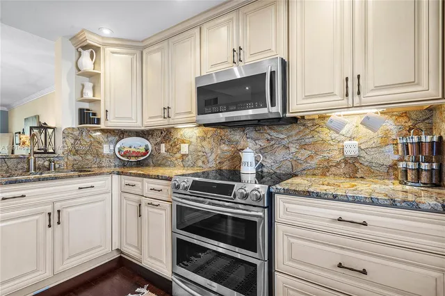 a kitchen with granite countertop white cabinets and appliances