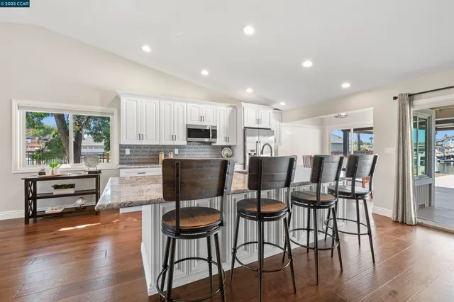 a kitchen with kitchen island a stove a dining table and chairs