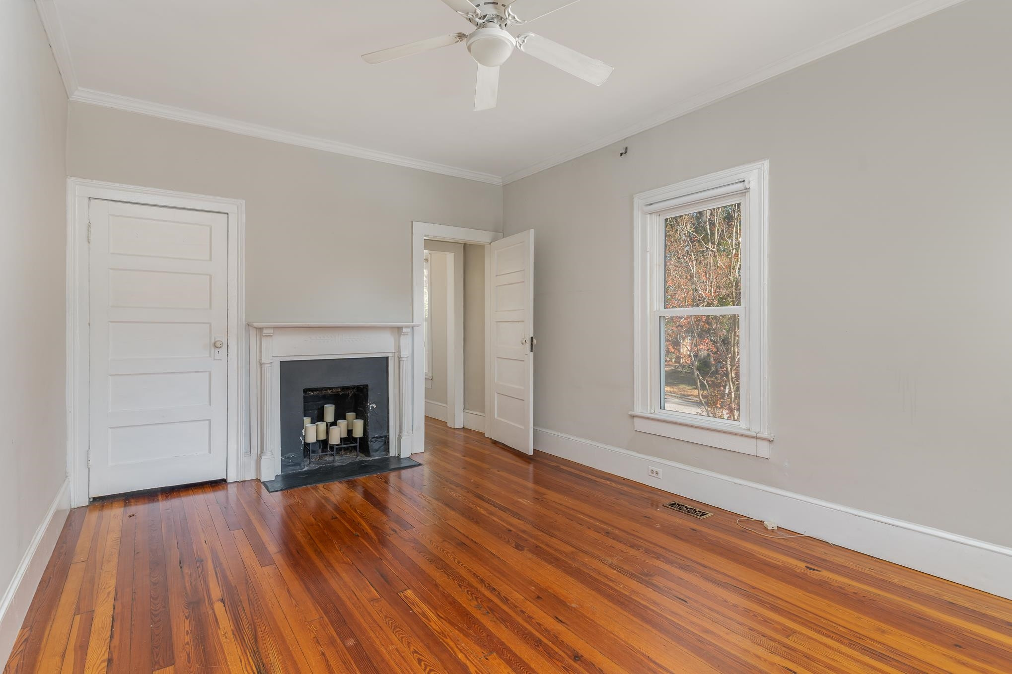 519 Holden Street Raleigh, NC 27604 - Photo 12 of 23 an empty room with wooden floor a fireplace and windows