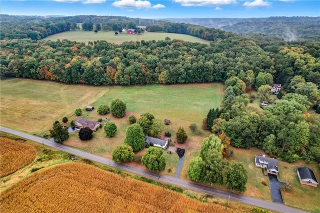 an aerial view of a house with a garden and lake view