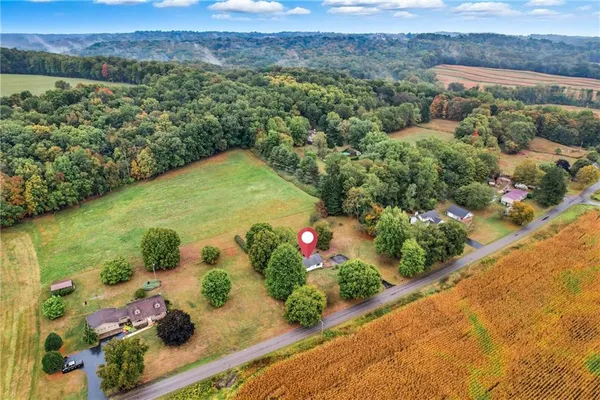 an aerial view of a house with a garden and lake view