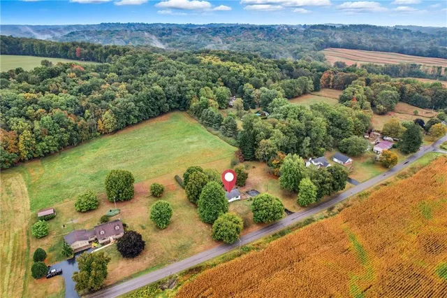 an aerial view of a house with a garden and lake view