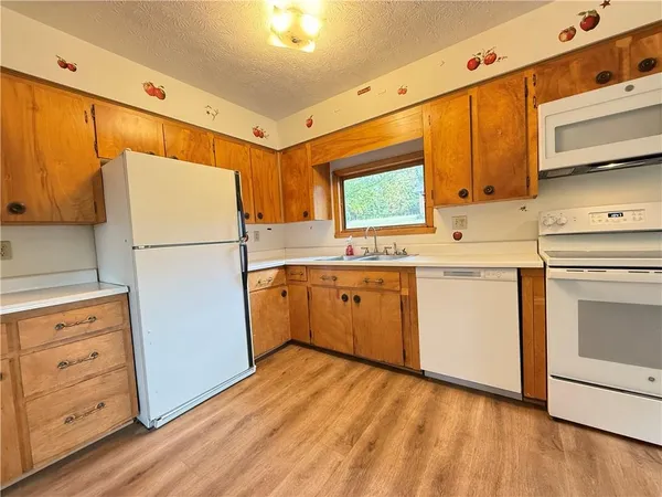 a kitchen with white cabinets and white appliances