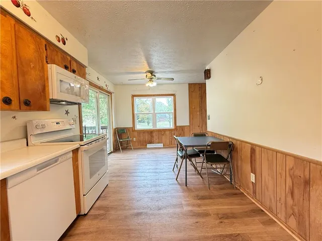 a dining hall with stainless steel appliances granite countertop a stove and a refrigerator