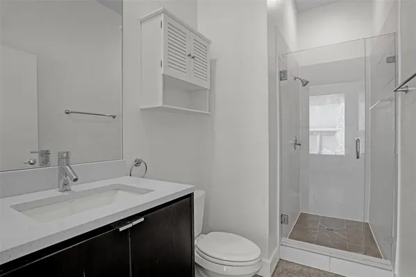 a bathroom with a sink a toilet a shower and a mirror