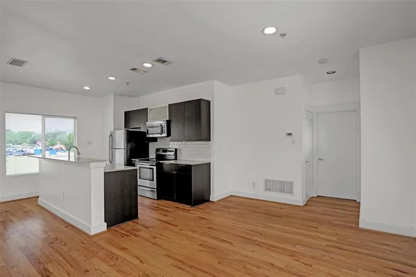 a kitchen with a refrigerator and a stove top oven