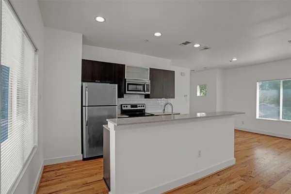 a kitchen with stainless steel appliances a microwave a sink and a refrigerator