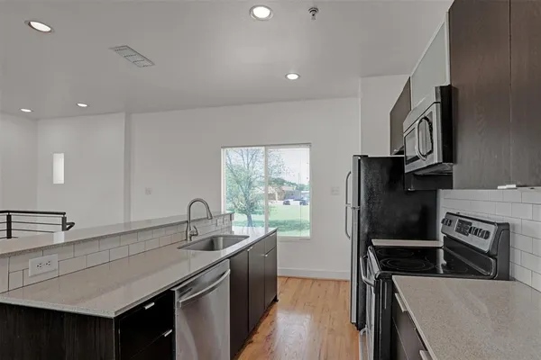 a kitchen with stainless steel appliances a sink stove and refrigerator