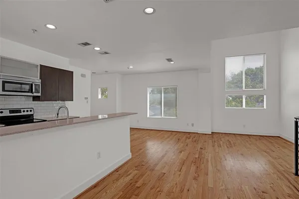 a kitchen with granite countertop a sink window and cabinets
