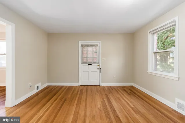 wooden floor in an empty room with a window