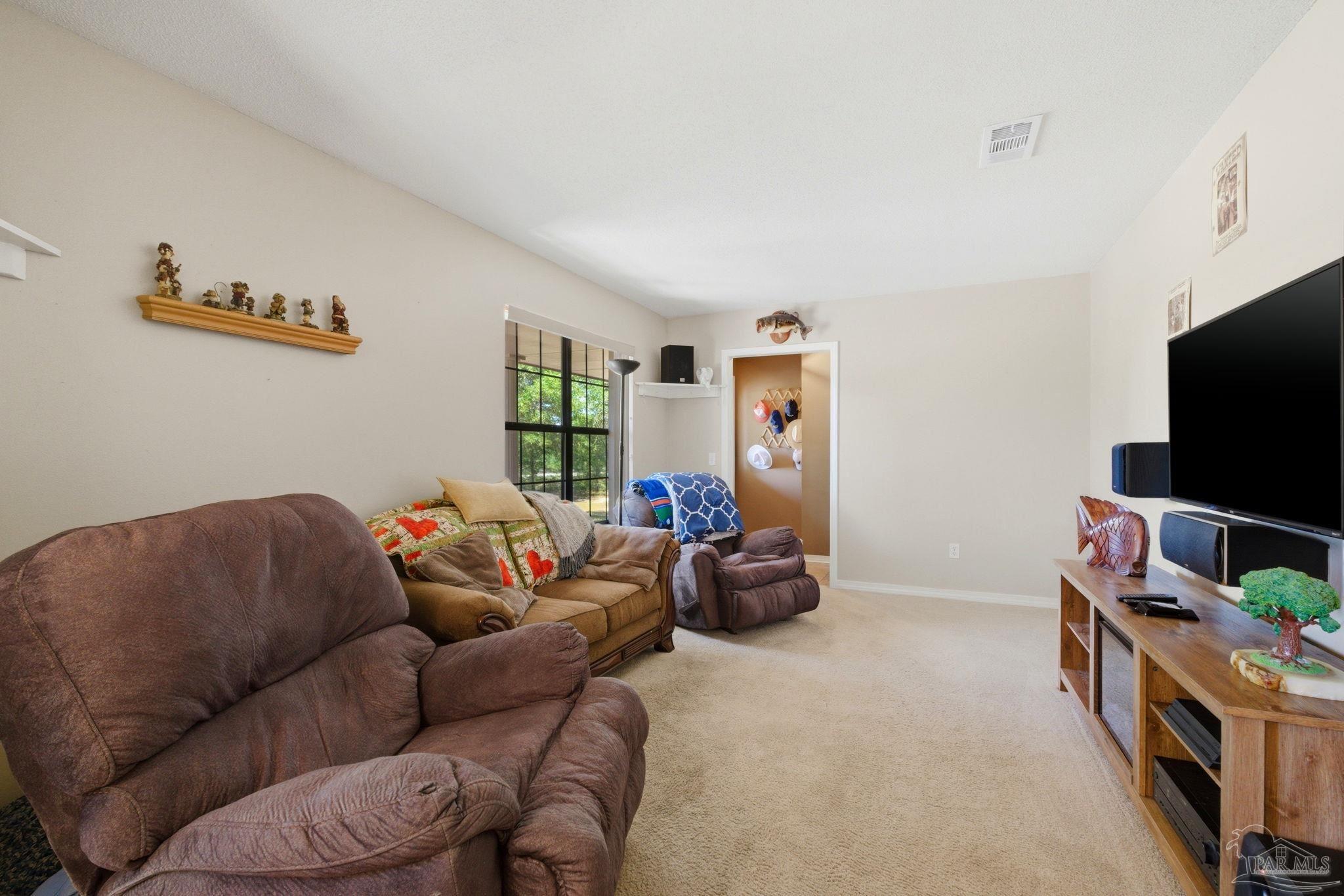 5121 Keyser Mill Road Baker, FL 32531 - Photo 6 of 52 a living room with furniture and a flat screen tv
