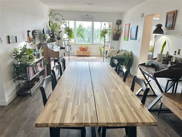 a view of an empty room with wooden floor and a ceiling fan