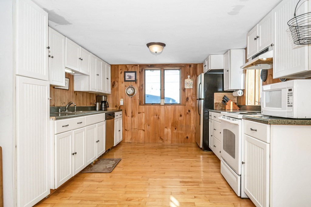 326 Mountain Road Lyndeborough, NH 03082 - Photo 5 of 41 a kitchen with white cabinets and white appliances