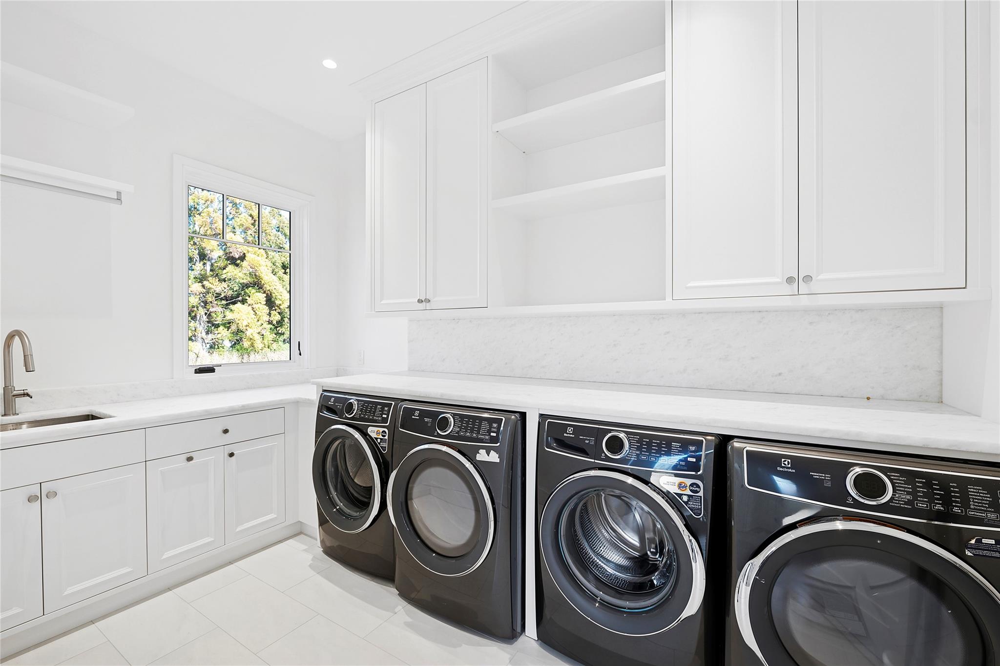 25 Fresh Pond Road North Haven, NY 11963 - Photo 13 of 32 Laundry room with light tile patterned flooring, cabinet space, a sink, and washer and dryer