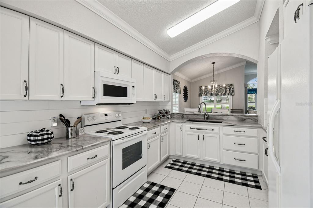 11647 Wheatfield Loop Hudson, FL 34667 - Photo 9 of 62 a kitchen with white cabinets and appliances