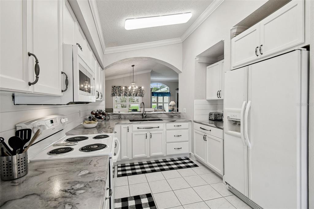 11647 Wheatfield Loop Hudson, FL 34667 - Photo 10 of 62 a kitchen with white cabinets and appliances