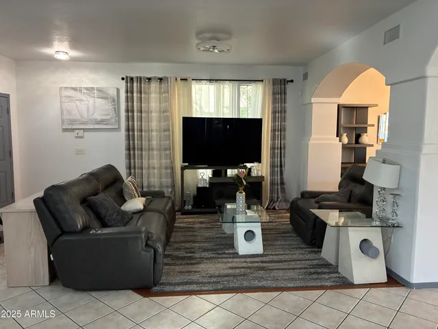 a living room with furniture a rug and a wall painting