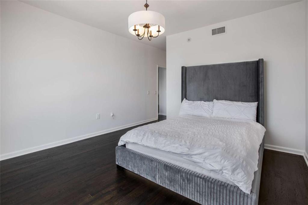 3475 Oak Valley Road Northeast, Unit 1630 Atlanta, GA 30326 - Photo 26 of 38 a bedroom with a bed and wooden floor