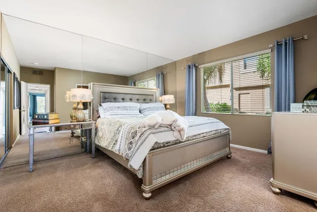 a bed sitting in a spacious bedroom next to a window