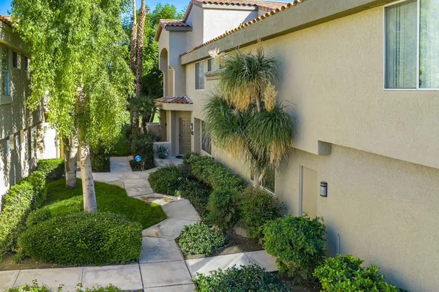 a front view of a house with a yard and potted plants