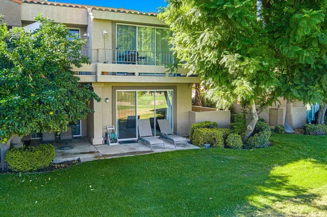 a view of a house with backyard sitting area and garden