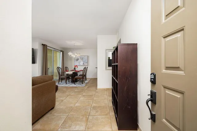a living room with furniture and a refrigerator