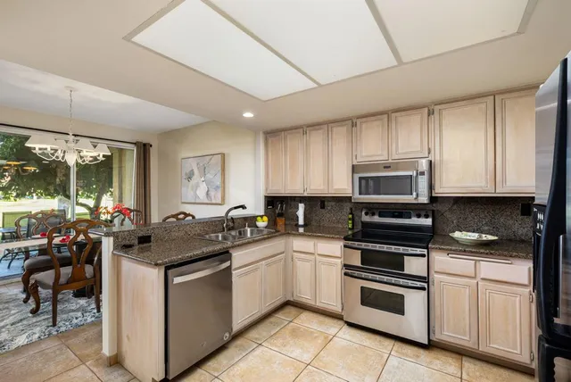 a kitchen with a sink stove top oven and cabinets