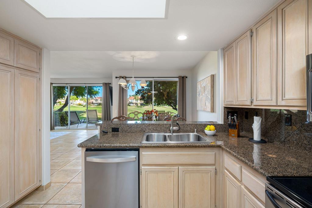 55406 Laurel La La Quinta, CA 92253 - Photo 9 of 50 a kitchen with stainless steel appliances granite countertop a sink a stove and a wooden cabinets
