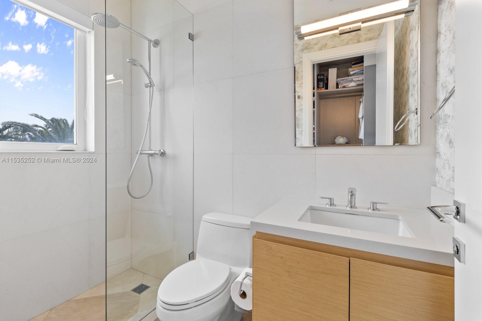 381 Beechwood Drive Key Biscayne, FL 33149 - Photo 17 of 23 a bathroom with a toilet sink vanity and shower