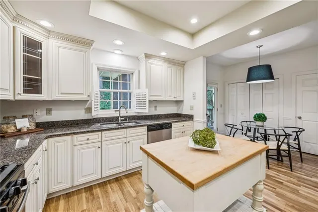 a kitchen with granite countertop white cabinets and white appliances