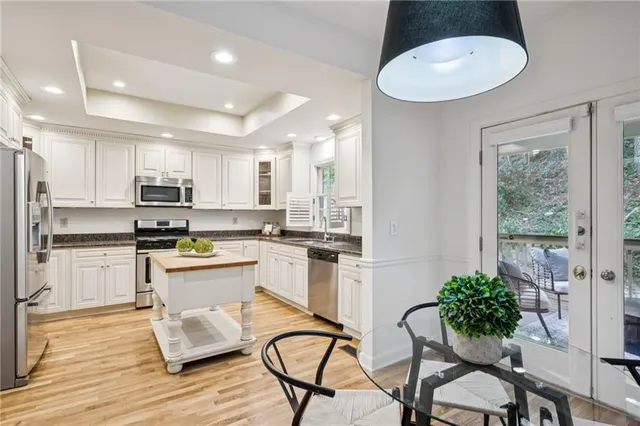 a kitchen with granite countertop white cabinets and stainless steel appliances