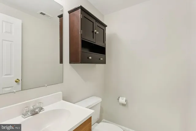 a bathroom with a toilet sink and mirror