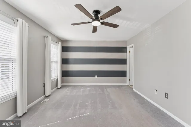 a view of an empty room with a ceiling fan