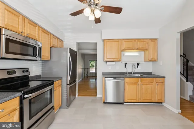 a kitchen with stainless steel appliances granite countertop a stove a sink and a refrigerator