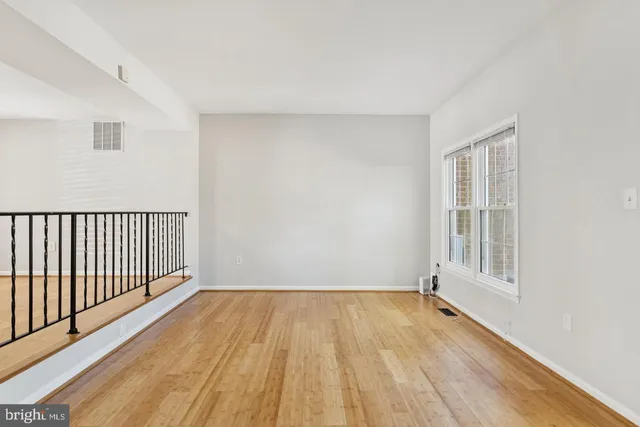 a view of a room with wooden floor and windows