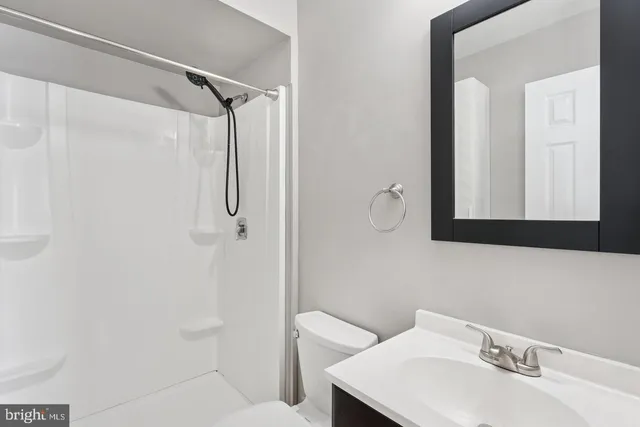 a bathroom with a sink vanity and shower