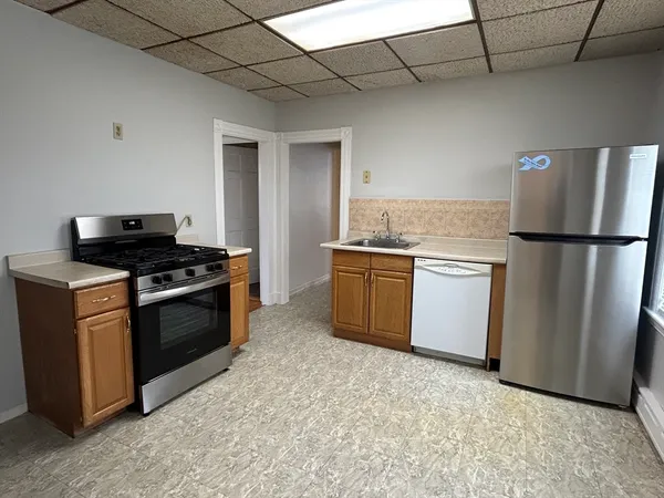 a kitchen with stainless steel appliances granite countertop a stove a sink and a refrigerator