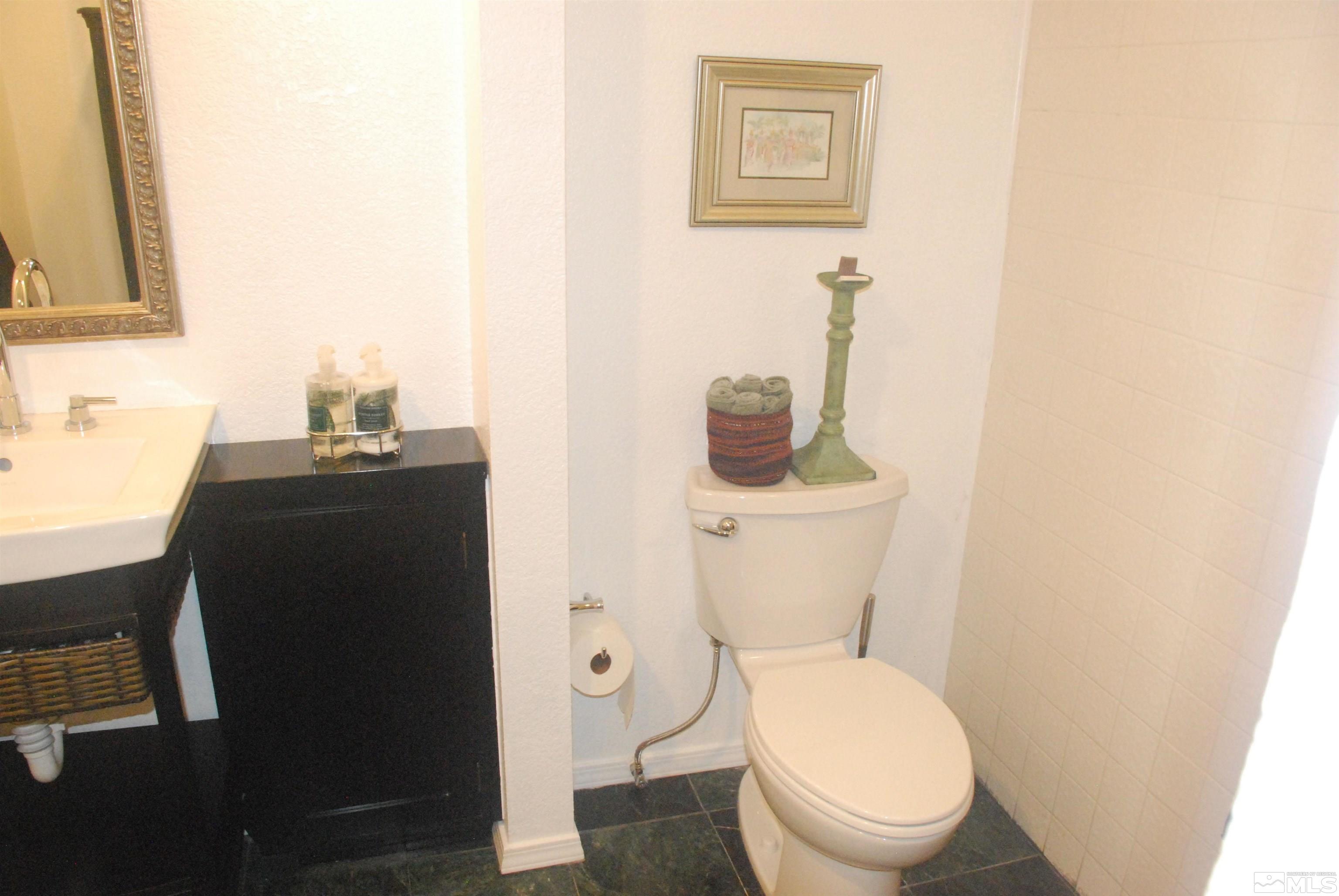 1200 Riverside Drive, Unit 1221 Reno, NV 89503 - Photo 23 of 35 a bathroom with a toilet a sink and mirror