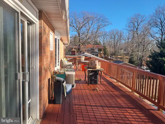 a balcony with chairs and wooden fence