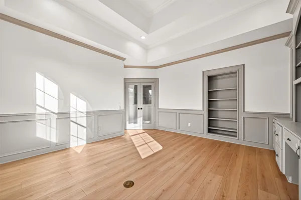 a living room with stainless steel appliances cabinets and a wooden floor